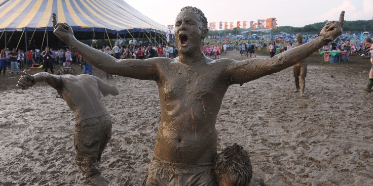 Festival goers covered in mud after a wrestling match during the 2009 Glastonbury Festival at Worthy Farm in Pilton, Somerset.